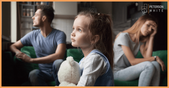 Mom and dad on couch, frustrated. Little girl holding bear looks in the distance.