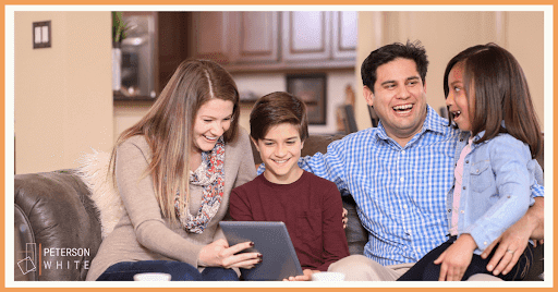 family sitting smiling looking at ipad