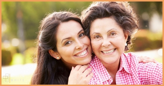 older woman and young adult smiling at camera